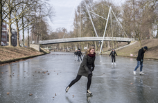 910712 Afbeelding van enkele schaatsers op een bevroren Stadsbuitengracht ter hoogte van de Catharijnesingel te ...